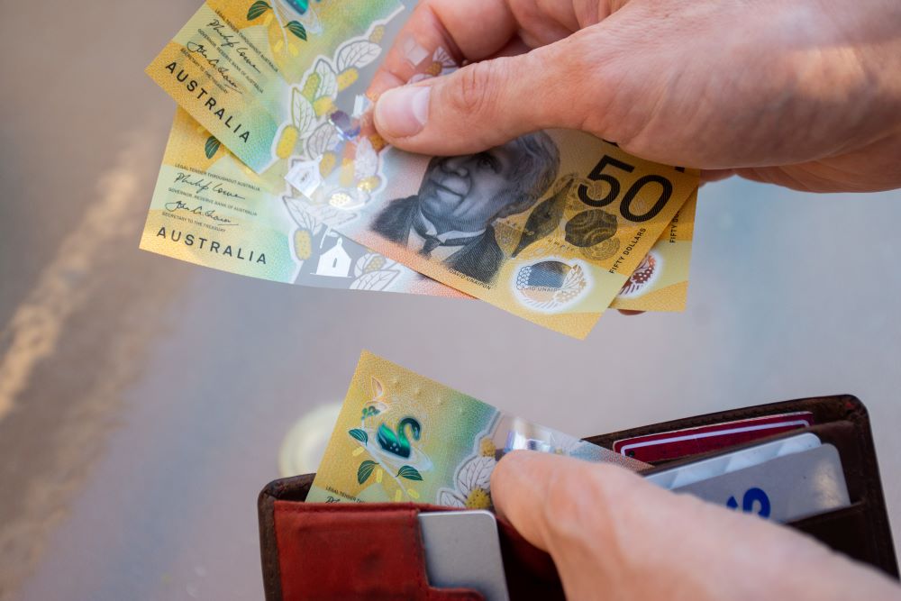 Hands holding wallet with australian dollars